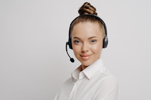 Beautiful call center consultant in white shirt in black headset photo