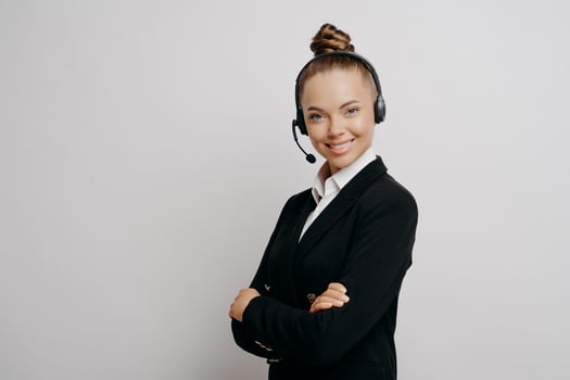 Friendly business woman in headset in dark suit ready for web conference photo