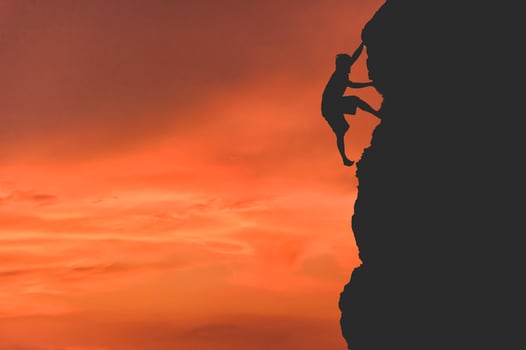 silhouette of a business woman with flags on top of a mountain above sky and sunlight photo