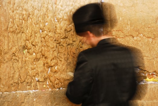 Traditional Hassidic Man Praying at the Western Wall moving as a candle in the wind. photo