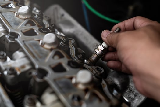 Old Car spark plug in a hand of Technician remove and change in engine room blur background service concept photo
