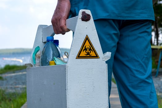 Biohazard sign on the box with samples of water from the lake in the hands of an employee photo