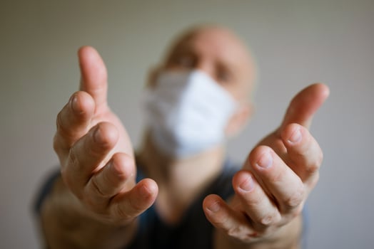 A man in a medical mask pulls his arms forward photo