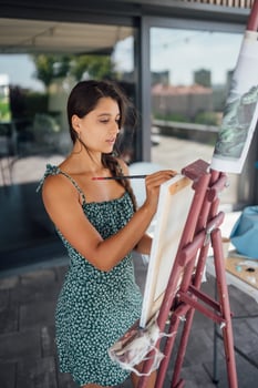Woman drawing her picture on canvas with oil colors photo