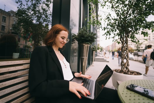 Beautiful woman working on laptop at outdoors cafe photo
