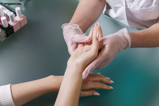 Manicurist does professional light hand massage after manicure procedure. photo