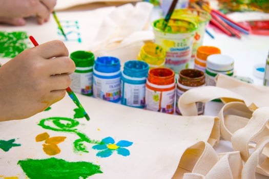 Brush in the children's hand that draws a water colors photo