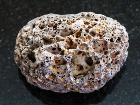 tumbled brown pumice stone on dark background photo