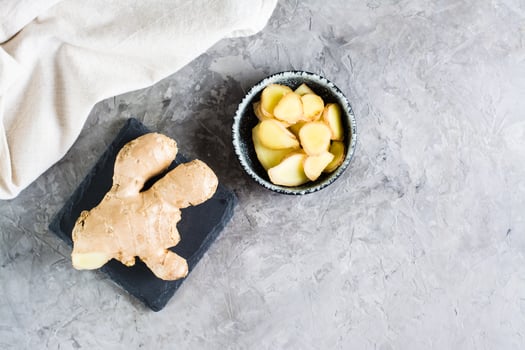 Sliced fresh raw ginger root in a bowl on the table. Alternative medicine. Top view photo