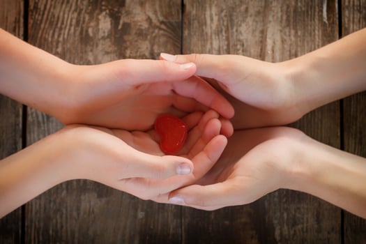 small red heart lies in the hands of men and women, the concept of love and romance photo