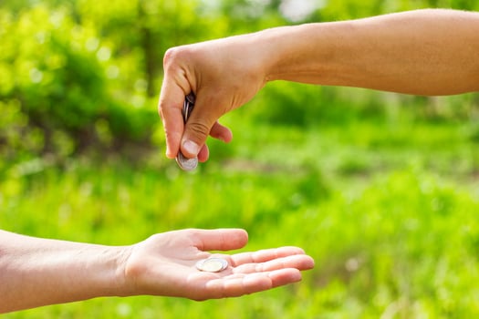 hand in hand gives coins on green background, Finance concept and loans. photo