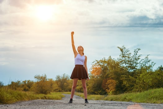 young girl standing on the road with her hand up, the concept of success. photo