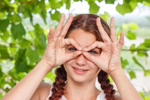 cheerful smiling girl shows hand gesture all OK in nature photo