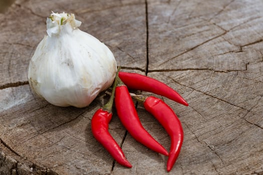 Red hot pepper lies on a wooden background with garlic photo