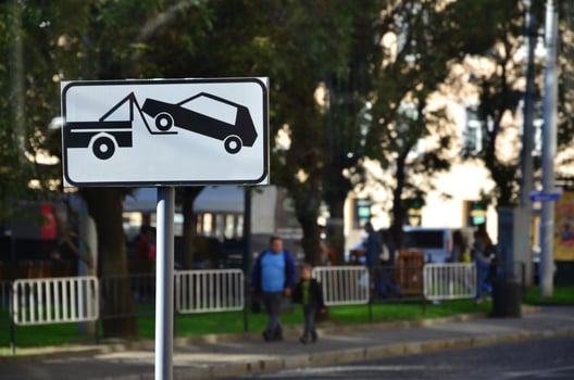 A road sign that shows a car tow truck, which raises a passenger car on board photo