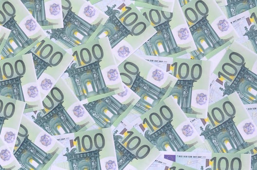 Background pattern of a set of green monetary denominations of 100 euros. A lot of money forms an infinite heap photo