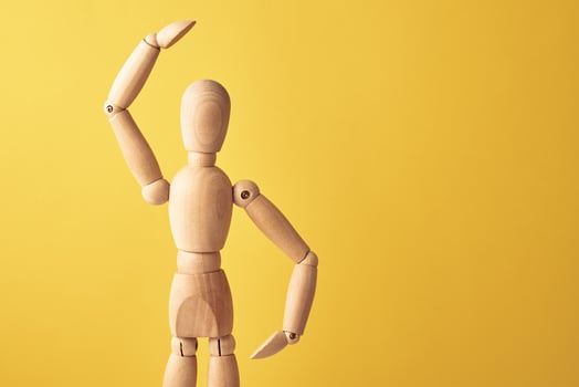Wooden doll on yellow background photo