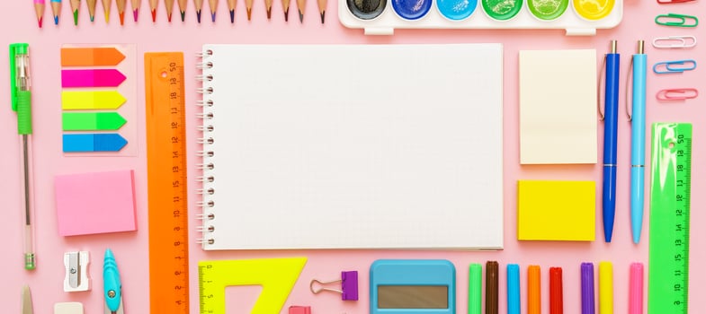 School supplies, stationery on pink background. Pens pencils notepad. Flat lay photo