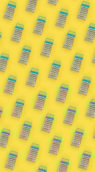 Small stainless steel graters lies on a pastel colored paper. Kitchen accessories. Tools for cooking. Flat lay top view photo