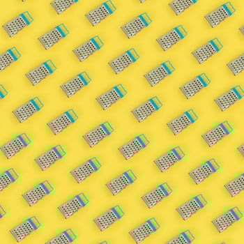 Small stainless steel graters lies on a pastel colored paper. Kitchen accessories. Tools for cooking. Flat lay top view photo