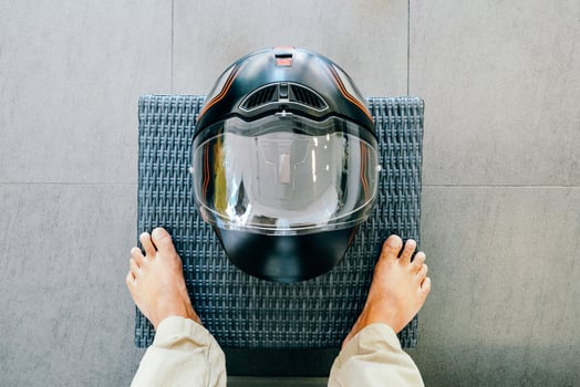A man standing in front of a full face helmet at home photo