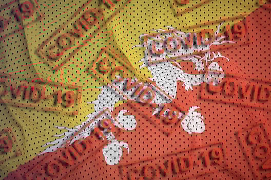 Bhutan flag and many red Covid-19 stamps. Coronavirus or 2019-nCov virus concept photo