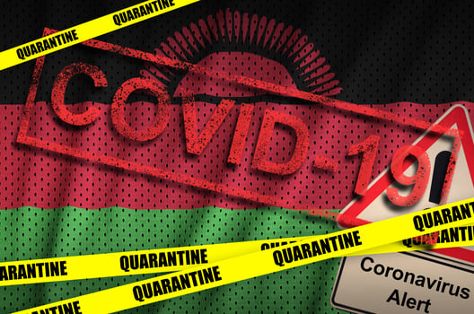 Malawi flag and Covid-19 quarantine yellow tape with red stamp. Coronavirus or 2019-nCov virus photo