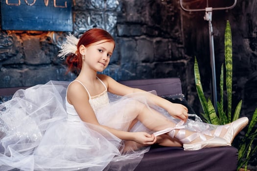 Girl in a white ball gown and shoes, beautiful red hair. Young theater actress photo