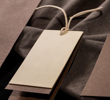 A closeup shot of a blank clothing tag on a string for a price label on a cloth photo