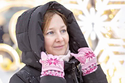 Portrait of a young woman warmly dressed on the street against the background of Christmas decorations on a snowy cold day photo