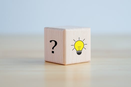 Idea and creativity concept. Creative process concept and problem solution. Glowing light bulb idea and question mark on wooden block. photo