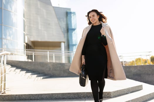 Businesswoman in stylish clothes walks up the steps of the office, career growth concept photo
