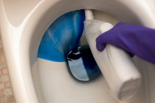 washing the toilet bowl in the bathroom with detergent and rubber gloves photo