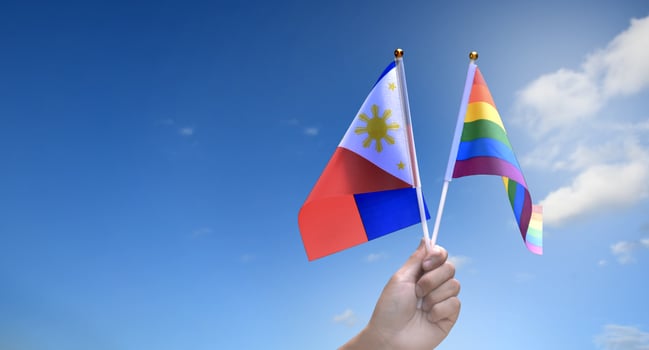 Rainbow flag and Philipines national flag holding in hand, soft and selective focus, concept for celebration of lgbtq in pride month around the world. photo