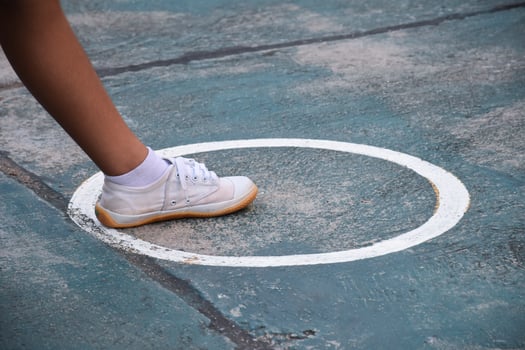 Young southeast asian female sepak takraw player step her left foot in the serving center area of the court, outdoor sepak takraw playing after school, soft and selective focus. photo