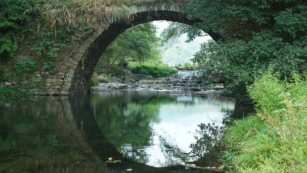 The old arched stone bridge view located in the countryside of the China photo