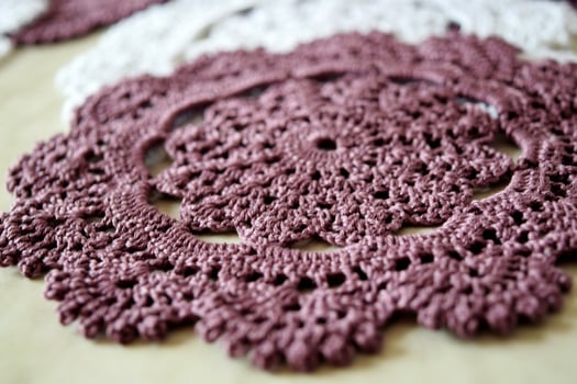 White and purple hand hooked coaster. Knitted holders for hot work photo
