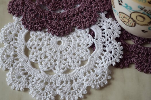 White and purple hand hooked coaster. Knitted holders for hot work photo