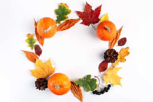 Decorative autumn composition of leaves, berries and pumpkins on white background. photo