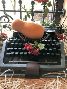 A small yellow pumpkin and red mountain ash lie on a typewriter. photo