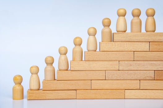 Wooden people figure on top of wooden blocks. Goal achievement, business growth and career progression photo