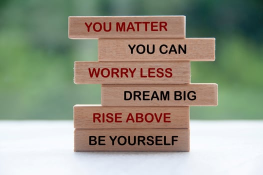 Inspirational words on wooden blocks - you matter, you can, worry less, dream big, rise above, be yourself. Inspirational and motivational concept photo