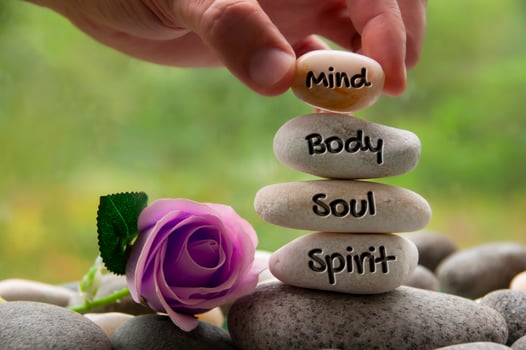 Mind, Body, Soul and Spirit words engraved on zen stones with rose flower. Copy space and zen concept photo