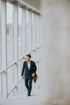 Young business executive with briefcase going up the stairs photo