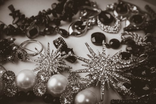 Beautiful precious shiny jewelery trendy glamorous jewelry set, necklace, earrings, rings, chains, brooches with pearls and diamonds on a black and white background. Flat lay, top view, copy place photo