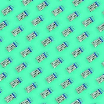 Small stainless steel graters lies on a pastel colored paper. Kitchen accessories. Tools for cooking. Flat lay top view photo