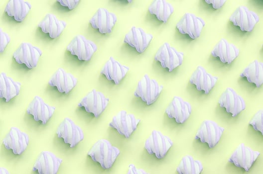 Colorful marshmallow laid out on lime paper background. pastel creative textured pattern photo