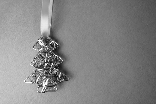 Festive Christmas Happy New Year black and white joyful background with a small toy metal iron golden homemade Christmas tree. Flat lay. Top view. Holiday decorations photo