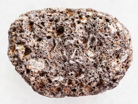 brown pumice stone on white marble background photo