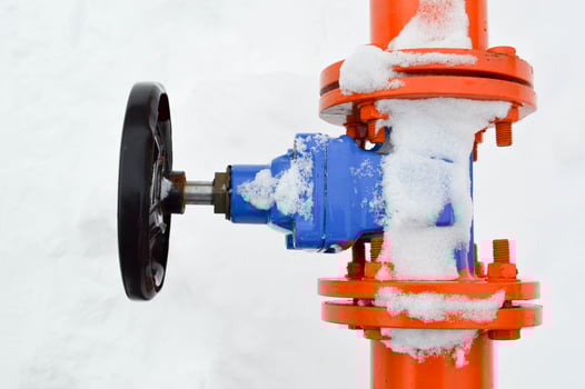 Industrial shut-off regulating protective pipe fittings. Black valve for opening, closing on an iron orange metal pipe with flanges, studs, nuts against the background of white snow in winter photo